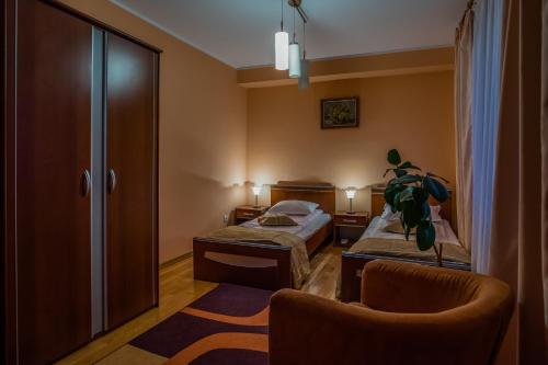 勒德乌齐Hotel Maria的酒店客房,配有两张床和椅子