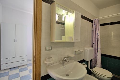 佩斯科勒海滨Mansarda Canarina的一间带水槽、卫生间和镜子的浴室