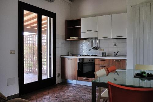 普林希匹纳马尔Azienda Agrituristica Il Giuggiolo的厨房配有白色橱柜、桌子和窗户。