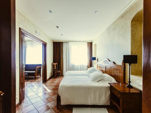 CintruénigoHotel Maher的酒店客房设有一张大床和一张书桌。