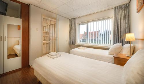 奥德多普奥德尔普酒店的酒店客房设有两张床和窗户。