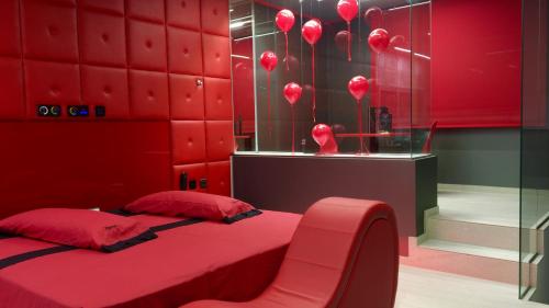 MecoMotel Venus Madrid Norte的红色卧室配有床和椅子