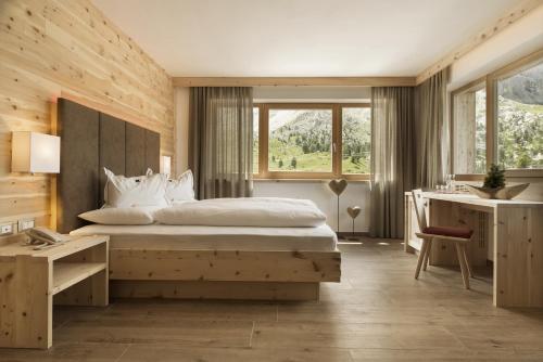 塞尔瓦迪加尔代纳山谷帕苏蝶鞍多洛米蒂山度假村 的一间卧室配有一张大床和一张书桌