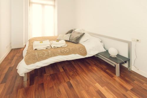 阿利坎特Modern Apartment - Alicante的一间卧室配有一张床,铺有木地板