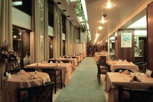 伊兹密尔雨穆克格鲁酒店 的餐厅的一排餐桌,配有白色床单