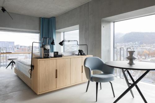 苏黎世苏黎世普莱西德设计与生活方式酒店的一间卧室配有一张床、一张桌子和一张桌子