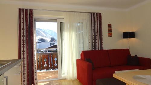 布鲁克安德格罗斯哥Appartements Gassner的客厅配有红色沙发和滑动玻璃门