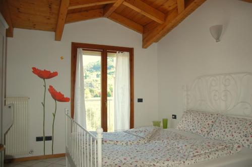 加尔达湖滨Appartamento Betulla的卧室配有白色的床和窗户。
