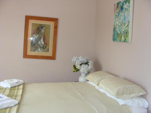 奥玛鲁奥马璐粉红色度假屋的一间卧室,配有一张床和花瓶