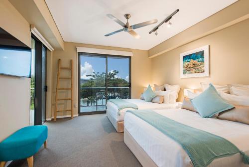 达尔文达尔文海滨豪华套房酒店的带窗户的客房内的两张床