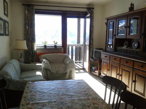 塞斯特雷Soleil Apartment的客厅配有桌椅和窗户。