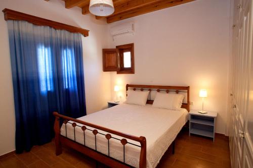 KámbosThea House Patmos的一间卧室配有床和蓝色窗帘