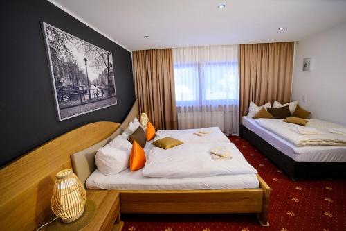 厄茨阿姆巴赫霍夫旅馆的酒店客房 - 带两张带橙色枕头的床