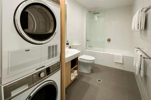 格里菲斯探秘格里菲斯公寓的浴室配有洗衣机和烘干机。