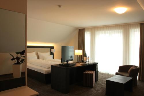 大博特瓦尔阿尔特希米德旅馆的酒店客房,配有床和电视