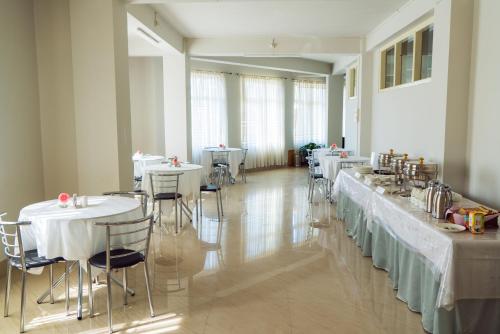KohīmaHotel Ariel的用餐室配有桌椅和白色桌子