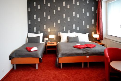 特夫尔多辛林姆巴CTT酒店的一间卧室配有两张带红色枕头的床。