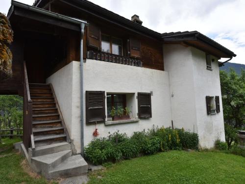 Grengiolsdetached holiday home in Grengiols Valais views的白色的房子,设有楼梯和窗户