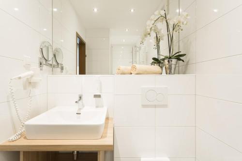 圣珀尔滕博克“罗特哈恩”酒店的白色的浴室设有水槽和镜子