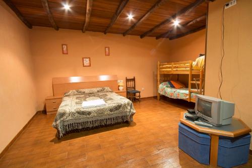CantagalloEl Tirol的一间卧室配有一张床、一台电视和双层床。