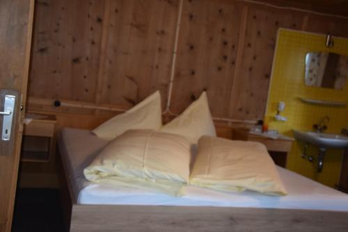 卡普尔Haus Sonnenhof的一张带白色床单和枕头的床