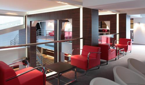 卢尔德蒙蒂特拉内酒店的一间设有红色椅子和桌子的等候室