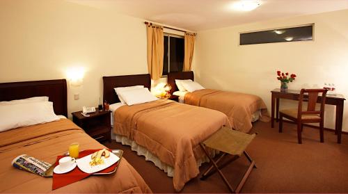 洛哈洛哈圣塞瓦斯蒂安酒店的酒店客房设有两张床和一张带食物盘的桌子。