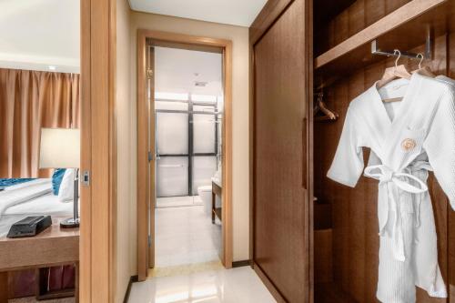 马尼拉Golden Phoenix Hotel - Manila的一间酒店客房,门上装有白色的长袍