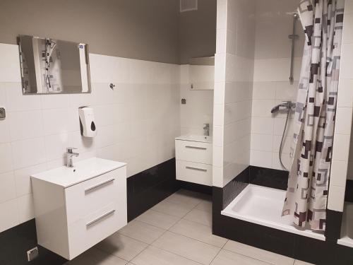 华沙杜斯卡旅馆的白色的浴室设有水槽和淋浴。