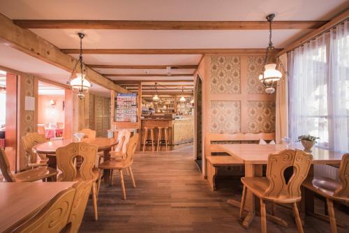 格尔兹维尔Gasthof Schoenegg B&B的一间带木桌椅的餐厅和一间酒吧