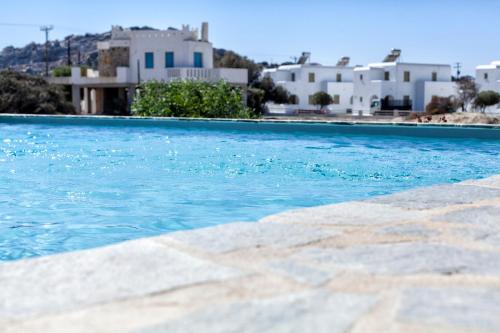 米科利维亚Casa Perla的蓝色的海水游泳池,后面有白色的建筑