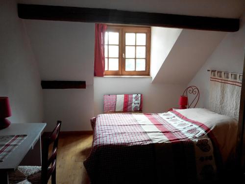 鲁法克Gite duplex du vignoble Alsace的一间卧室配有一张床、一张桌子和一个窗户。