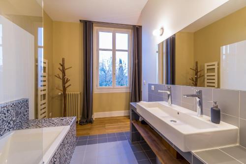 阿尔比L'Autre Rives的一间带两个盥洗盆和大镜子的浴室