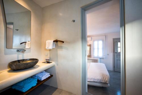 AgaliBlue Sand Boutique Hotel & Suites的一间带水槽和床的浴室