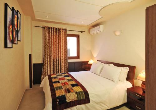 非斯莱斯奥利弗斯套房＆Spa公寓式酒店的卧室配有白色的床和窗户。