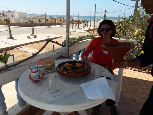 Tan-Tan PlageHotel Canarias Sahara的坐在餐桌旁吃一碗食物的女人