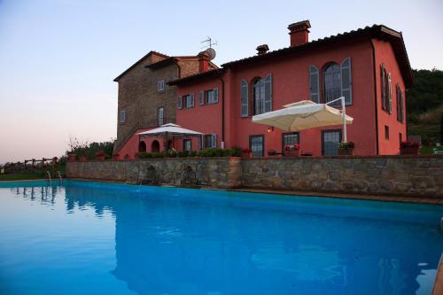 巴贝里诺·迪·穆杰罗Agriturismo Rimaggiori relaxing country home的大楼前带游泳池的房子