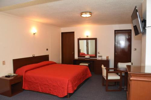 贾拉普哈拉帕维多丽亚酒店的酒店客房配有红色的床和书桌