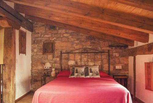 Laguna del MarquesadoLa Lagunilla的一间石墙卧室,配有红色的床