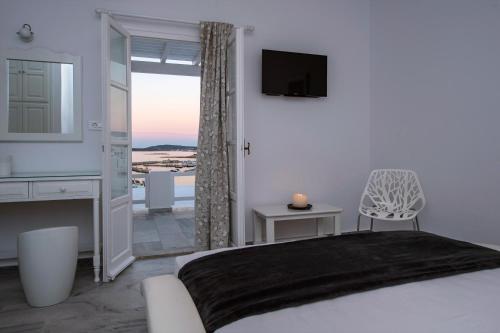 纳乌萨Villa Irini的一间卧室设有一张床、一台电视和一个窗口。