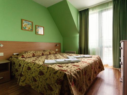 普罗夫迪夫布莱特豪斯宾馆的一间卧室设有一张带绿色墙壁的大床