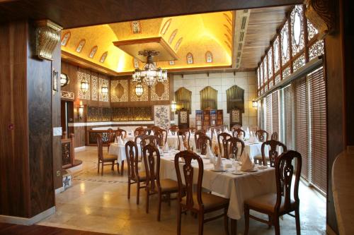安曼里安曼皇家酒店的一间带桌椅和吊灯的用餐室