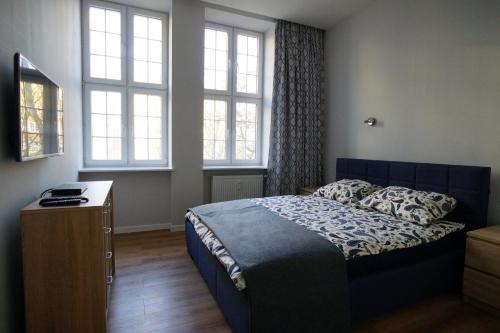 格但斯克Apartament MARIACKA 42的一间卧室设有一张床和两个窗户。