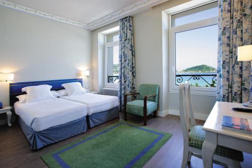 圣塞瓦斯蒂安妮扎酒店的配有一张床、一张书桌和一扇窗户的酒店客房