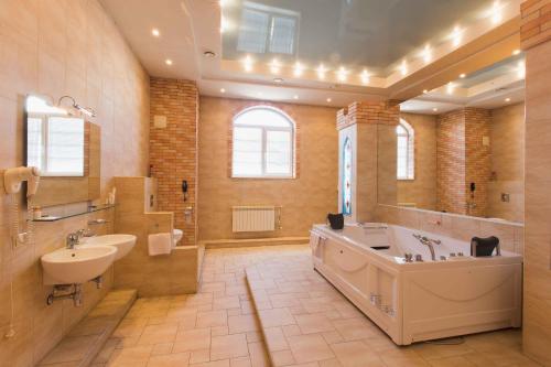 鄂木斯克柯莱特酒店的大型浴室设有大浴缸和水槽
