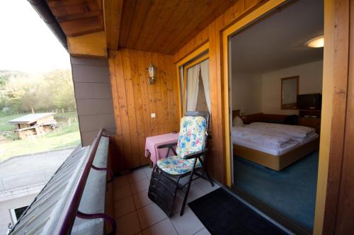 巴登-符腾堡赫辛朵夫穆尔酒店的客房设有带一张床和椅子的阳台。