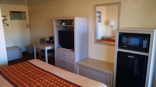 阿拉莫戈多白沙汽车旅馆的酒店客房设有一张床、一台电视和一间卧室。