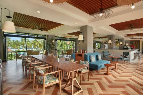 美娜多Manado Tateli Resort and Convention的餐厅设有一张大型木桌和椅子