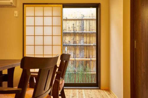 京都Kyoyado Hakuto的客房设有桌椅和窗户。