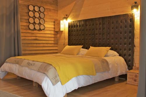 GennesEcolodges de Loire & Spa的一间卧室设有一张带木墙的大床